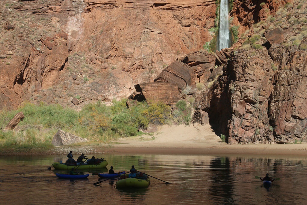 Photo by Byron Roos-Collins. Boaters passing in front of Deer Creek Falls.